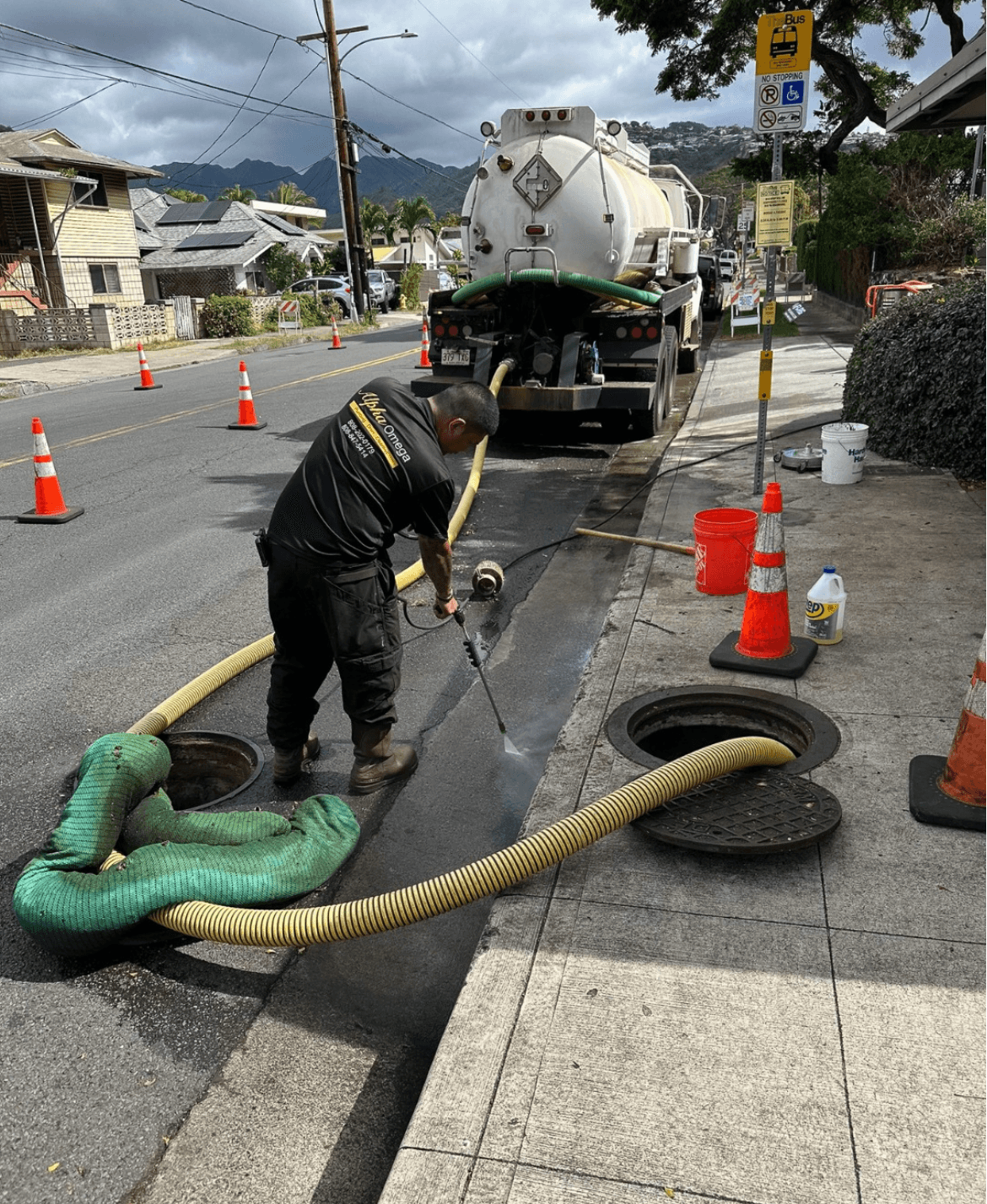 Alpha Omega pump truck operator clearing a street sewer on Oahu